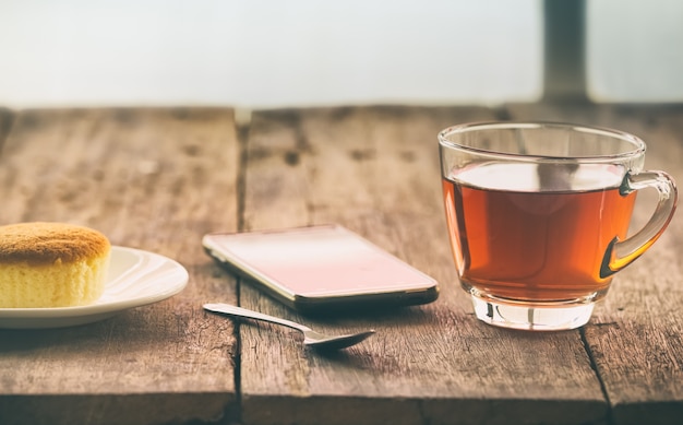 Weinlesetasse tee auf dem Hintergrund der hölzernen Tabelle morgens.