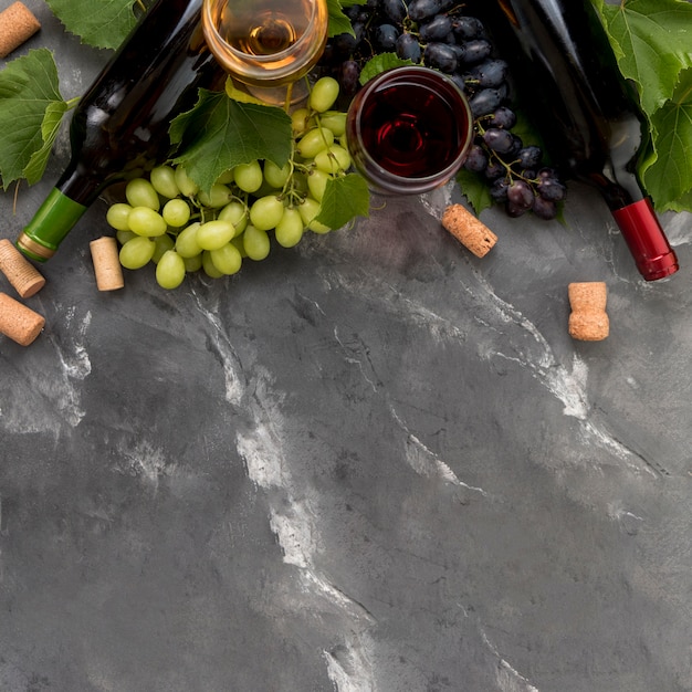 Weintraube mit Flasche Wein auf Marmorhintergrund