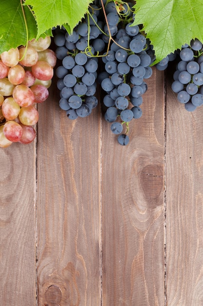 Weintraube und Weinrebe auf Holztisch