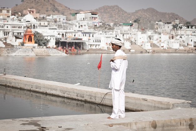 Weiß gekleideter Mann steht in der Nähe des Heiligen Sees von Pushkar in Pushkar, Indien