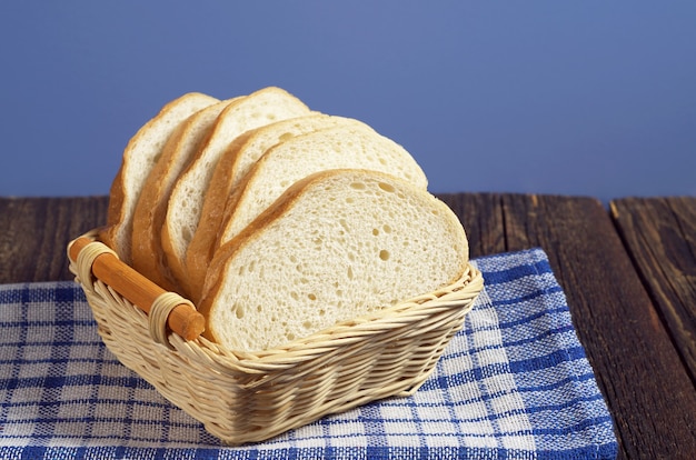 Weißbrot in Korbholzschale auf rustikalem Tisch