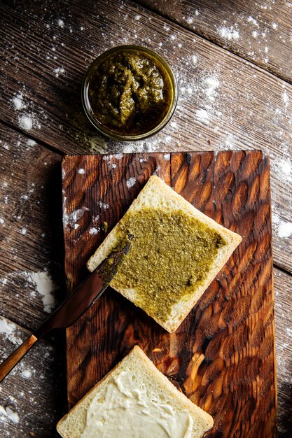 Weißbrotscheibe mit Pesto-Sauce bestreichen