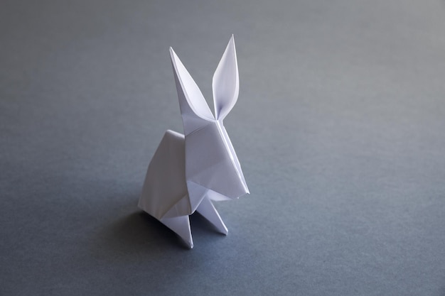 Weißbuch-Kaninchen-Origami isoliert auf grauem Hintergrund