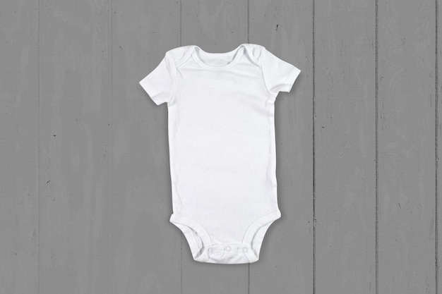 Weiße Babykleidung Mockup auf grauem Holzhintergrund