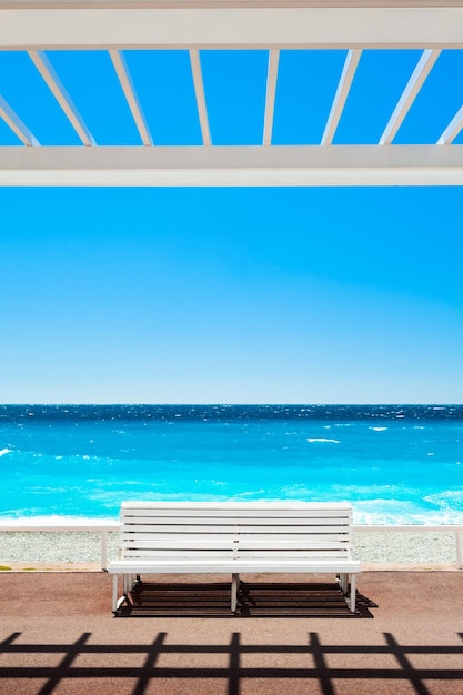 Weiße Bank an der Promenade des Anglais in Nizza, Frankreich. Wunderschönes türkisfarbenes Meer und Strand