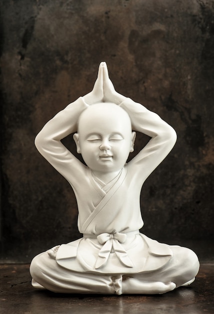Weiße Buddha-Skulptur auf dunklem Hintergrund. Meditation und Entspannung