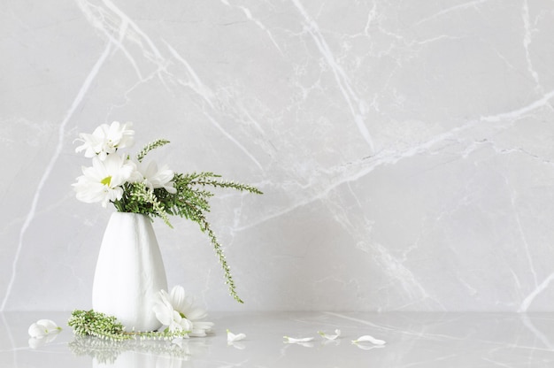Weiße Chrysanthemen in Vase a auf grauem Marmorhintergrund