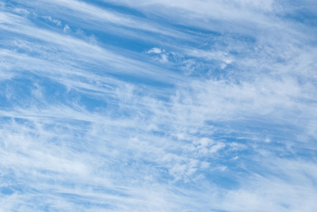 Weiße Cumulus- und Cirruswolken am blauen Himmel