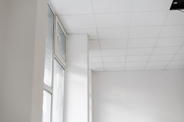 Weiße Decke im Büro. Weiße Decken können Licht gut reflektieren. Das richtige Licht bei der Arbeit. Abstraktes leeres weißes Innenraumbüro. Platz kopieren.