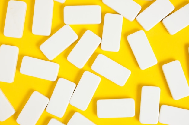 Weiße Dominosteine auf gelbem Hintergrund