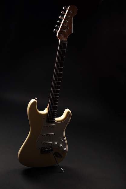 Weiße E-Gitarre auf schwarzem Hintergrund