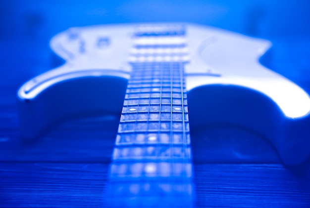 Foto weiße e-gitarre. musikkonzept. kreativer stil mit hellen schatten.