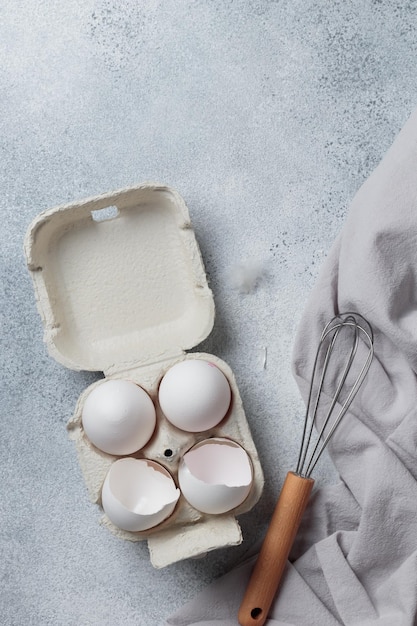 Weiße Eier in einer kleinen Papierbehälterbox, Draufsicht auf neutralem Hintergrund