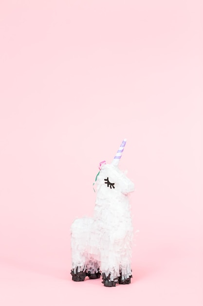 Weiße Einhorn-Pinata auf rosa Hintergrund.