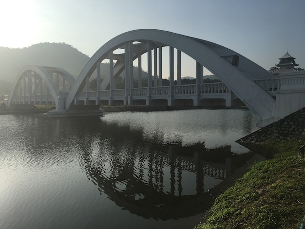 Weiße Eisenbahnbrücke über dem Sonnenaufgang des Sees morgens