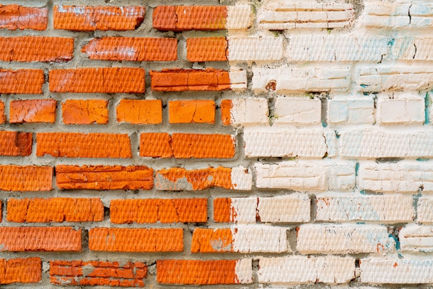 Weiße Farbe auf einer roten Backsteinmauer.