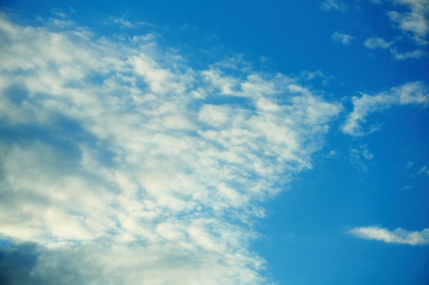 Weiße flache Kumuluswolkenbildung im blauen Himmel im sonnigen Sommertag Bewölkter blauer Himmel Dramatisches Wolkengebilde Unbeständiges Wetter