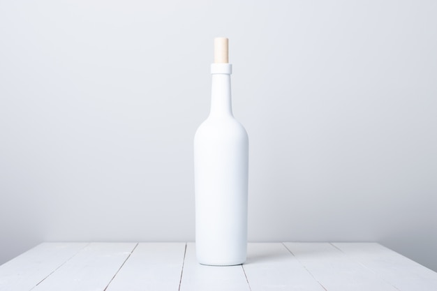 Weiße Flasche auf einem weißen Holztisch
