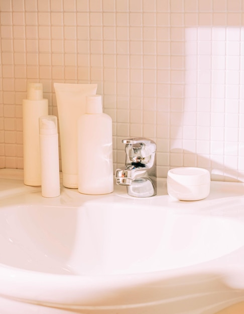 Weiße Flaschen mit verschiedenen Kosmetika stehen auf dem Waschbecken im Badezimmer. Sauberkeit und Ordnung im Haus