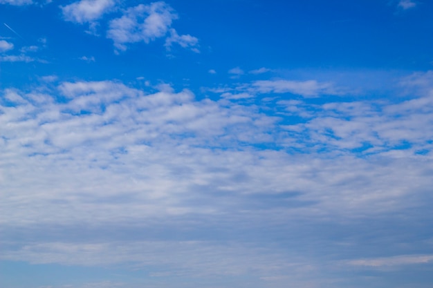 Weiße flauschige Wolken am blauen Himmel an einem sonnigen Sommertag.