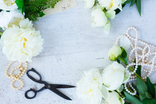 Weiße frische blühende Pfingstrosenblumen mit Perlenschmuck auf weißem hölzernem Desktoprahmen