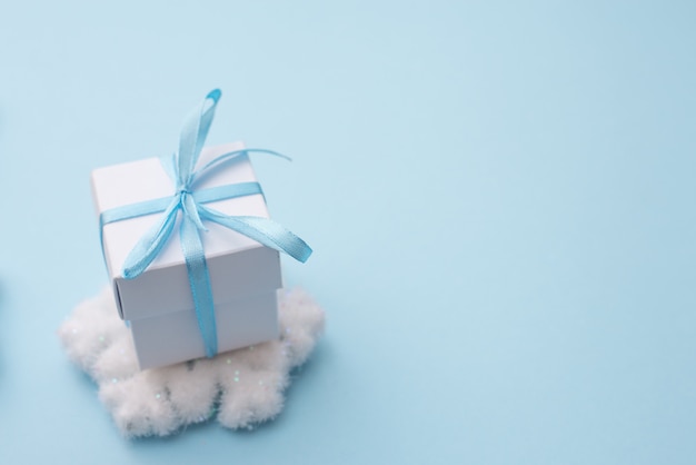 Weiße Geschenkbox auf Blau mit Schneeflocke, copycopyspace für Jahreszeitgruß guten Rutsch ins Neue Jahr, AF-Punktauswahl und verwischt.