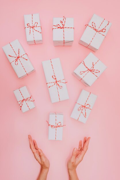 Weiße Geschenkboxen mit rotem Band auf einem rosa Hintergrund, Hintergrund am Valentinstag, Geburtstag, Jahrestag.