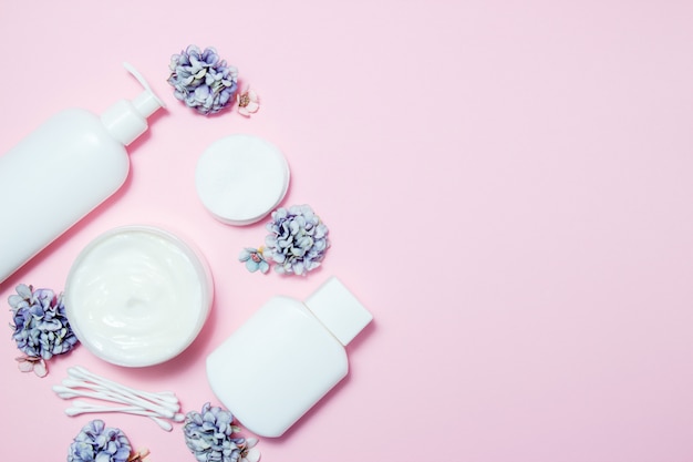 Foto weiße gläser kosmetik mit blumen auf rosa