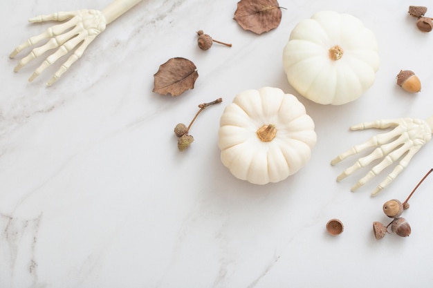 Weiße Halloween-Kürbisse mit Dekor auf Marmorhintergrund