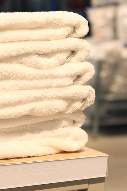 Weiße Handtücher in einem Laden in Nahaufnahme zu einem Stapel gefaltet Heimtextilien schöne Handtücher auf einem Regal gestapelt