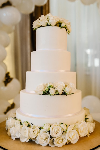 Weiße Hochzeitstorte mit Blumen geschmückt Geburtstagstorte auf dem Tisch