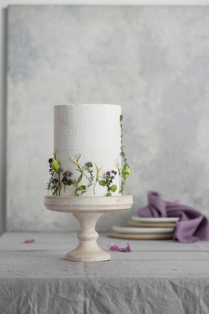 Weiße Hochzeitstorte mit lila und grünen Blumen