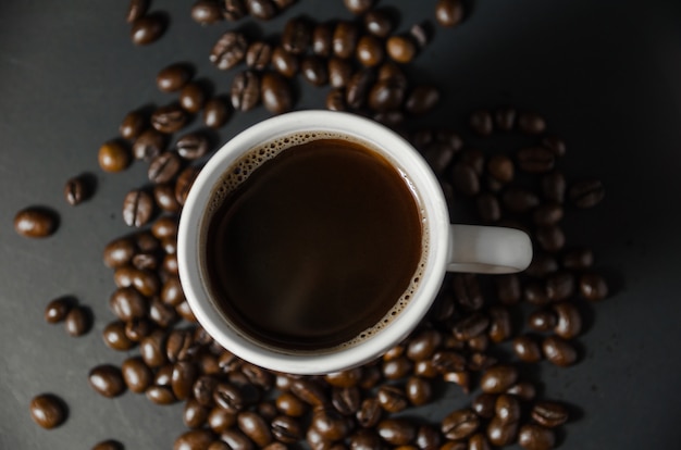 Weiße Kaffeetasse mit Kaffeebohnen auf Draufsicht