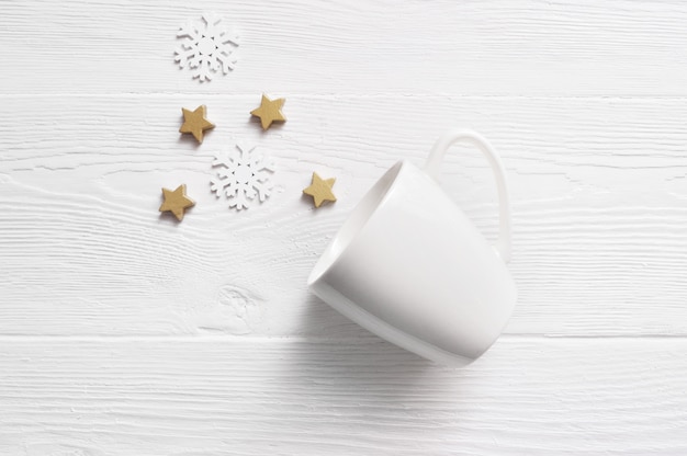 Weiße Kaffeetasse mit Weihnachtskegeln und -sternen.