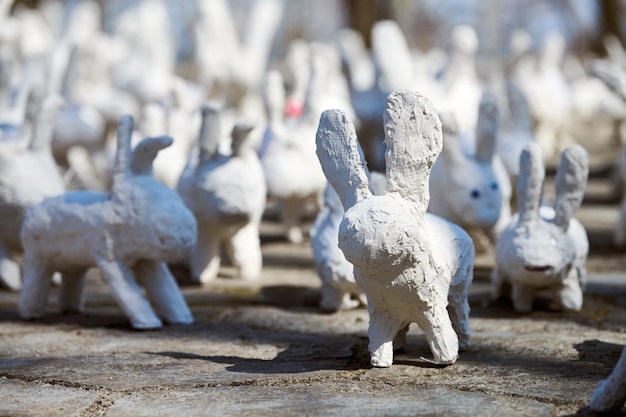 Weiße Kaninchenstatuen aus Gips auf der Kunstausstellung im Freien Lustige weiße Hasen auf der Straße