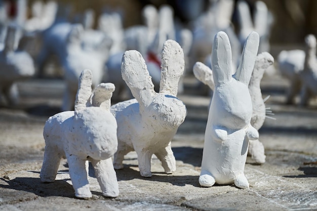 Weiße Kaninchenstatuen aus Gips auf der Kunstausstellung im Freien Lustige weiße Hasen auf der Straße