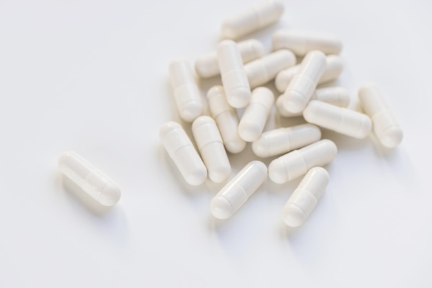 Weiße Kapselpillen auf weißem Hintergrund Supplement und Medizinkonzept Closeup Copy Space