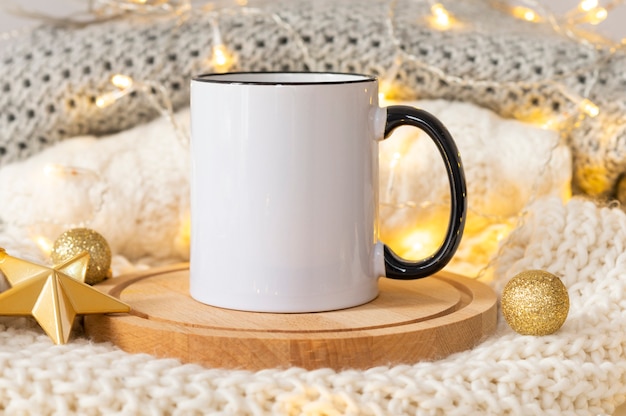 Weiße Keramikkaffeetasse mit schwarzem Griffmodell auf einem goldenen Weihnachtsdekorationshintergrundkopierraum