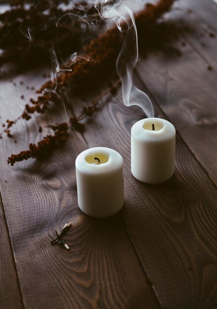 Weiße Kerzen, die auf hölzerner Tischplatte brennen