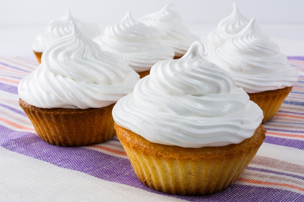 Weiße kleine Kuchen auf der Leinenserviette