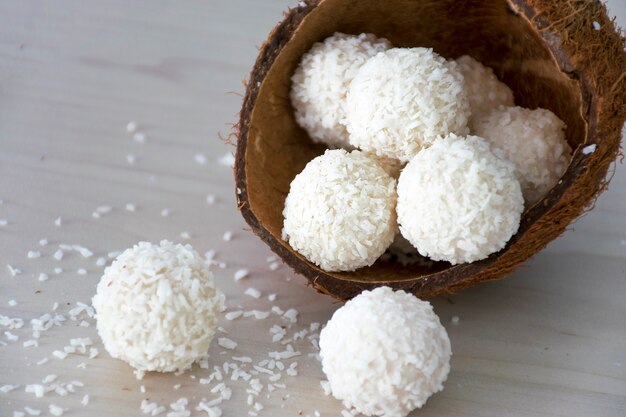 Weiße Kokosnussbonbonbällchen der hausgemachten Süßigkeiten in der Nussschale.