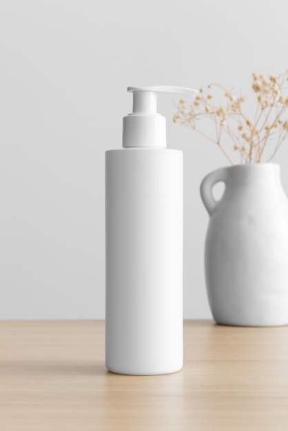 Weiße kosmetische Shampoo-Spenderflasche mit Gypsophila auf dem Holztisch