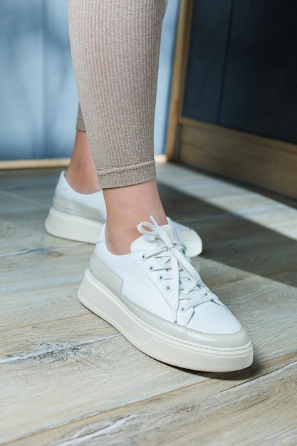 Weiße Leder-Damen klassische Turnschuhe auf den Füßen Stilvolle Damen-Schuhe für den Sommer Kollektion von Sommer-Damen-Schuhe
