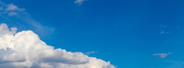 Weiße lockige Wolke am blauen Himmel unten schräg