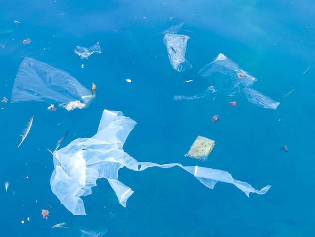 Weiße Plastiktüte, die im blauen Meer schwimmt