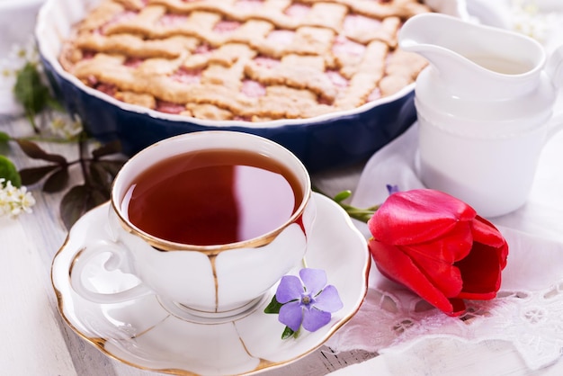 Weiße Porzellantasse Tee und frischgebackener Kuchen englisches Frühstück Stillleben mit Getränken und Leckereien rot