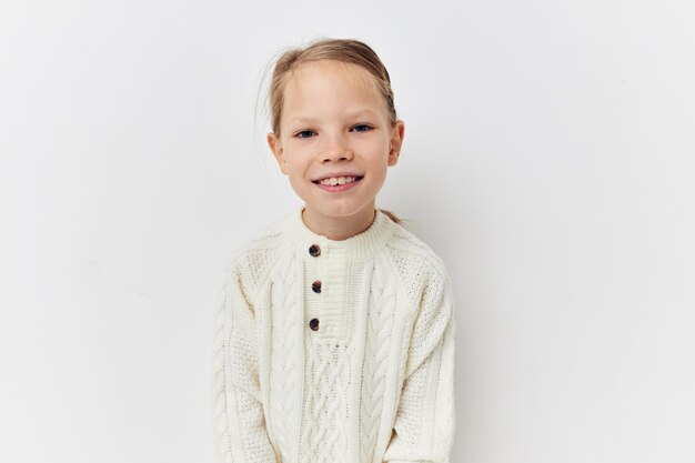 Weiße Pulloverhandgesten des kleinen Mädchens heller Hintergrund