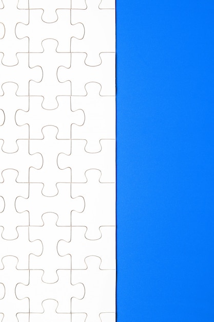 Weiße Puzzleteile auf blauem Hintergrund. Hintergrund für den Inhalt