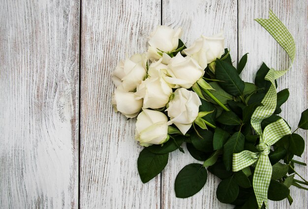 Weiße Rosen auf einem Holztisch