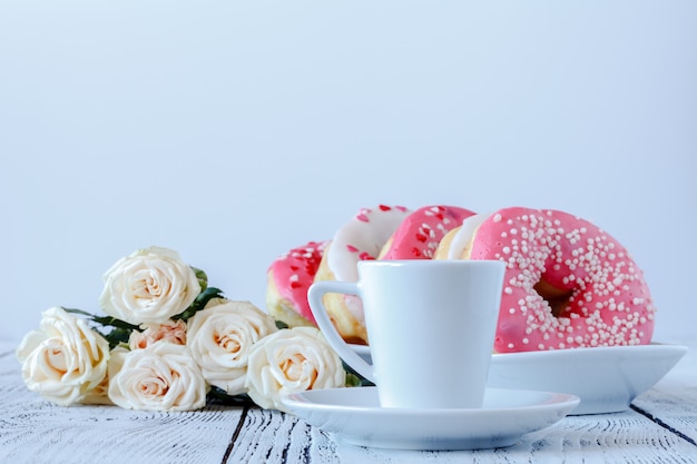 Weiße Rosen und schwarzer Kaffee auf Weiß